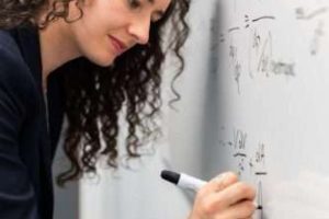 woman writing formula on whiteboard